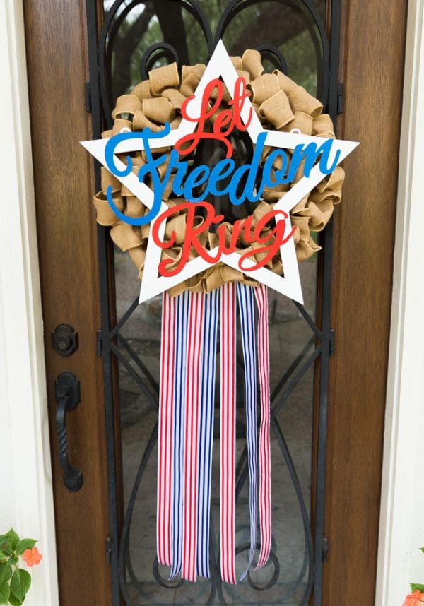 Burlap patriotic wreath with “Let Freedom Ring” sign and red, white, and blue ribbon streamers