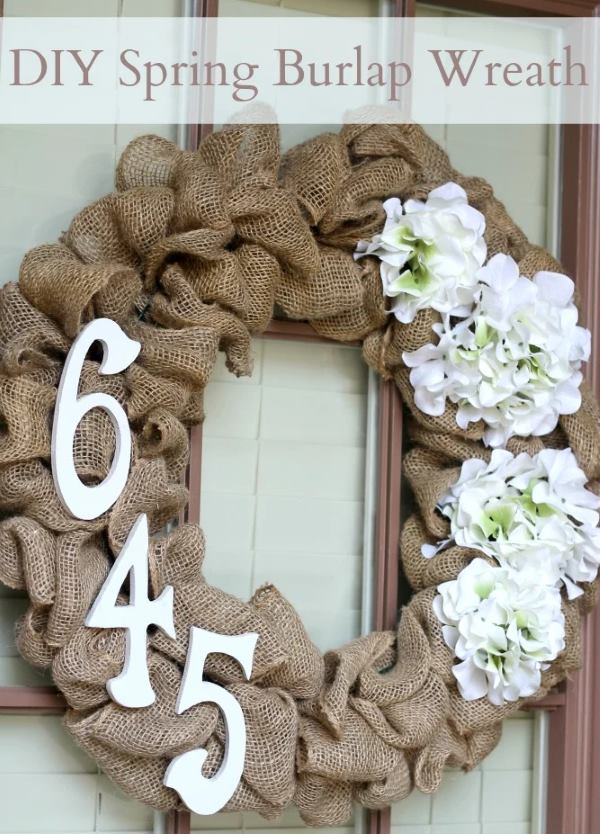 Rustic burlap wreath with white flowers and wooden 645 numbers hanging on front door