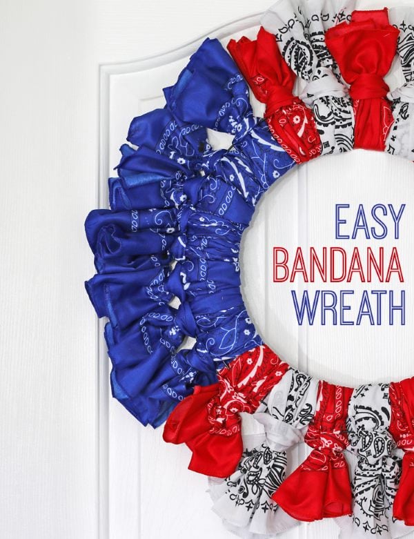Patriotic bandana wreath made with red, white, and blue tied fabric on white door