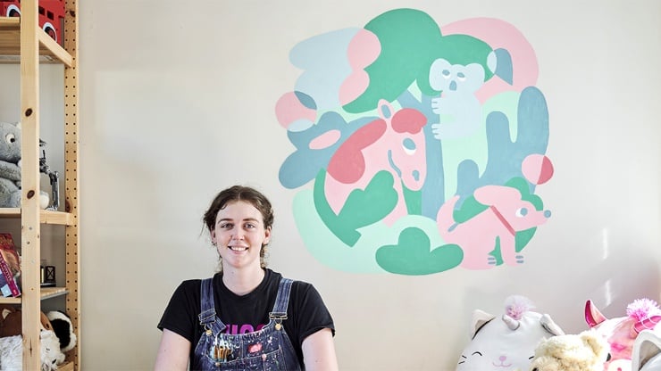 Whimsical woodland mural featuring hand-painted animals including a fox, koala, and unicorn in a child's bedroom.