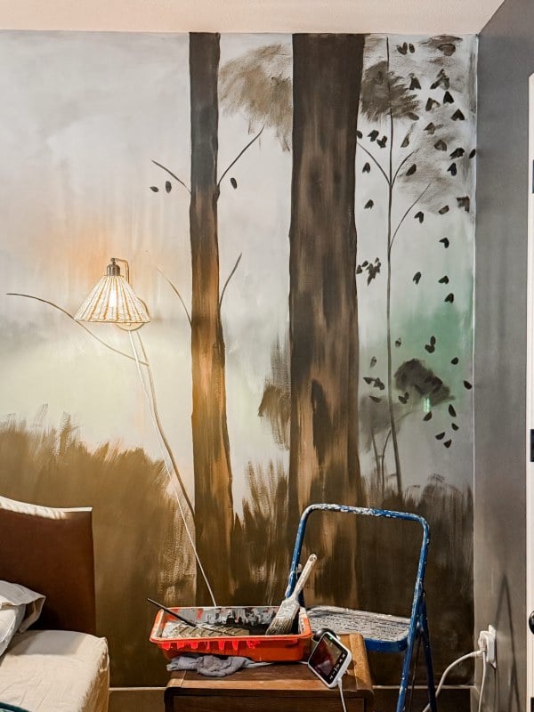 Moody forest mural with tall trees across a bedroom wall