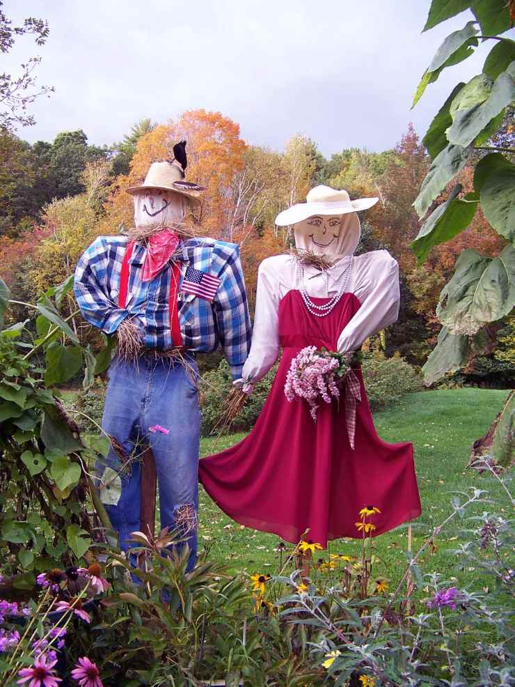DIY scarecrow bride and groom dressed for a whimsical fall wedding scene in the garden.