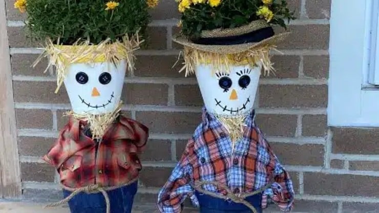 Two small DIY scarecrows made with painted flower pot heads, plaid shirts, and straw details.