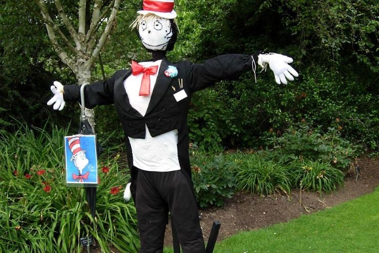 Cat in the Hat-inspired DIY scarecrow dressed in a black suit, red bow tie, and striped hat.